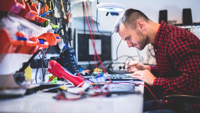 Man repairing laptop at workstation